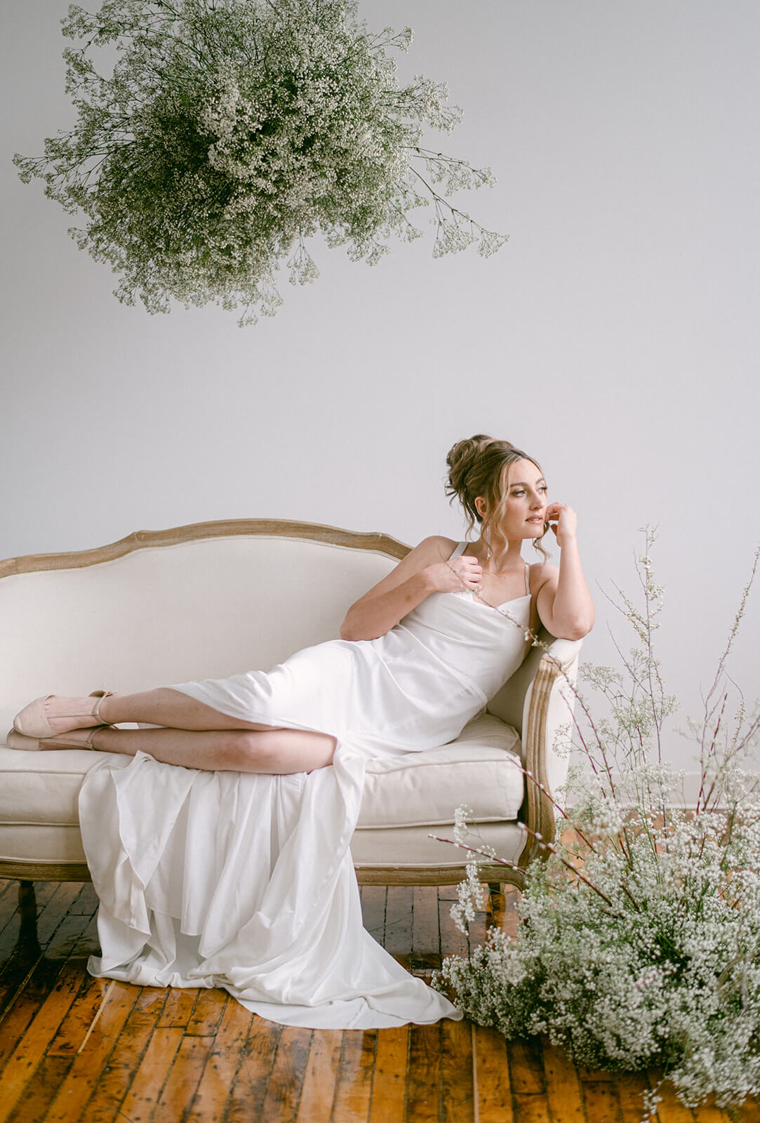 A bride sits on sofia settee at The Apiary